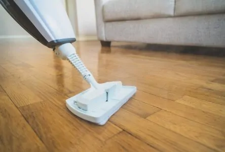Cleaning the living room floor with a white steam mop