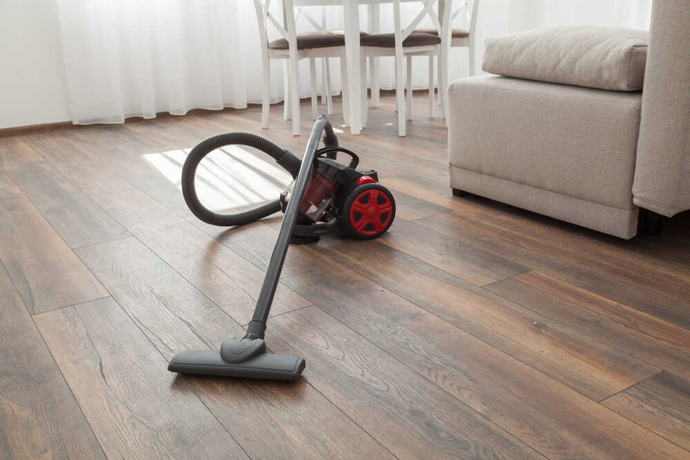 A canister vacuum on living room hardwood floor
