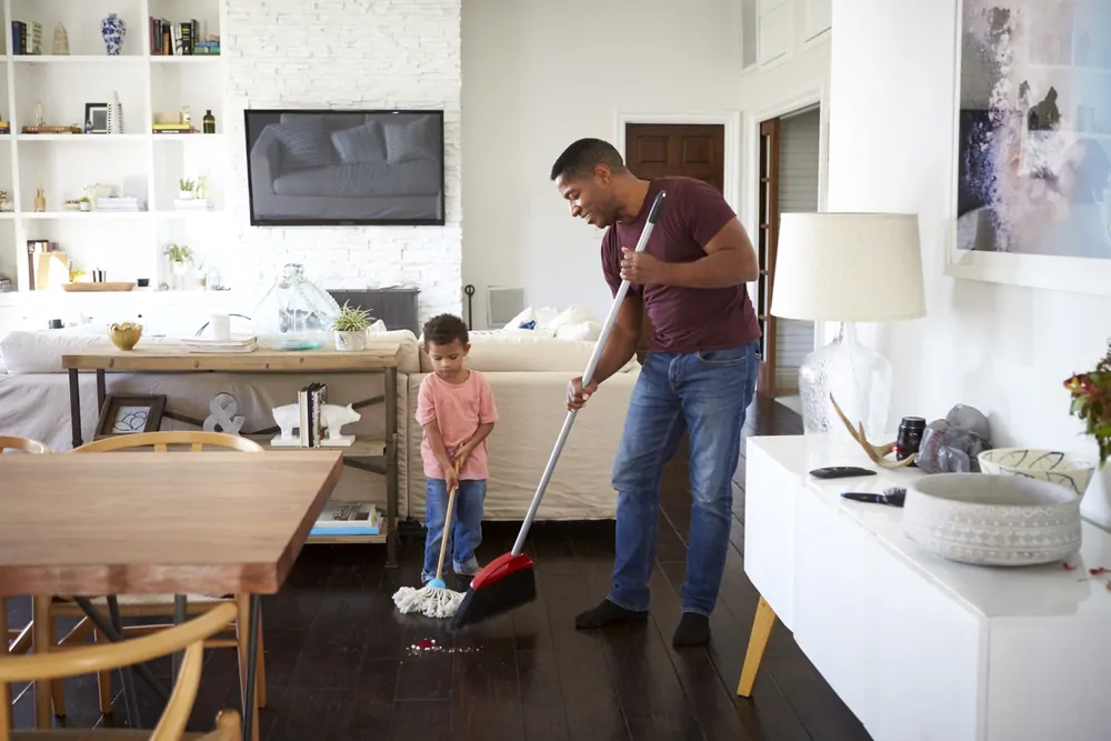 Father and son mopping their sitting room