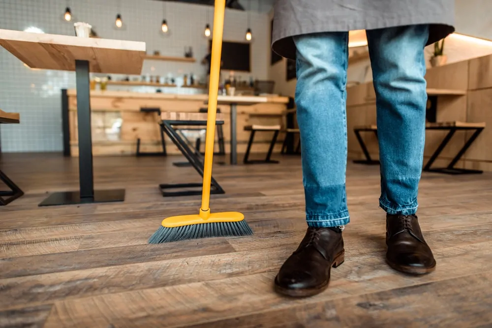 Sweeping a hardwood floor with a broom
