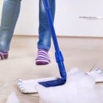 Mopping kitchen tile floor with cleaning solution