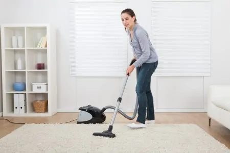 Woman cleaning area rug