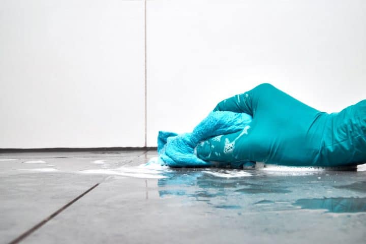 Man cleaning shower floors