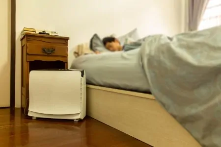 Person sleeping with an air purifier