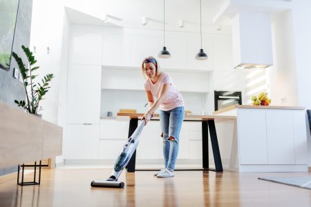 Woman cleaning laminate flooring with a steam mop