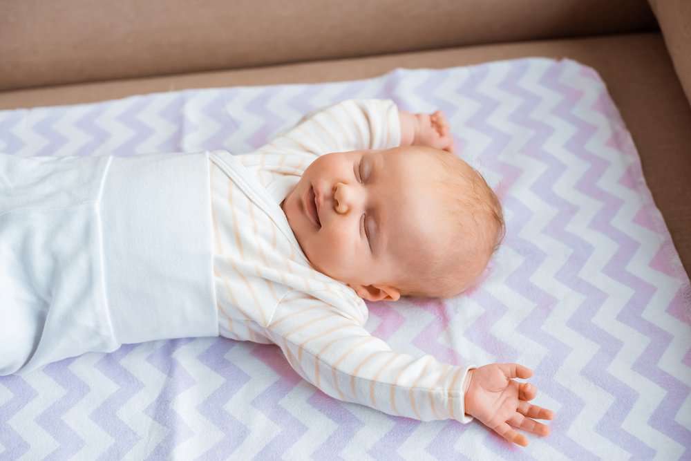 Baby sleeping in nursery with air purifier
