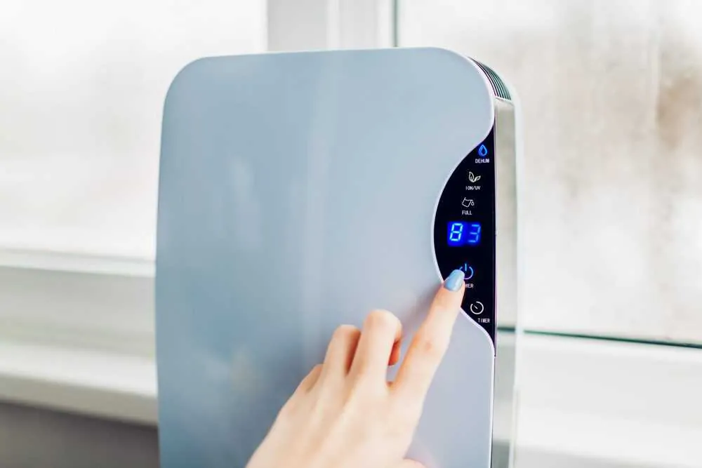 Woman turning on dehumidifier