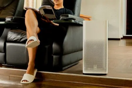 Man sitting on sofa beside an air purifier