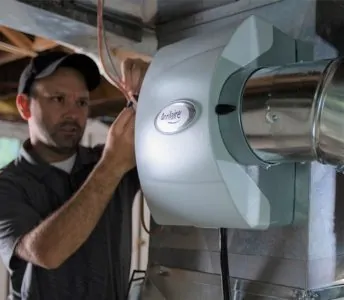 Man installing a furnace humidifier