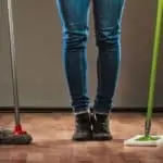 Woman holding two types of mops
