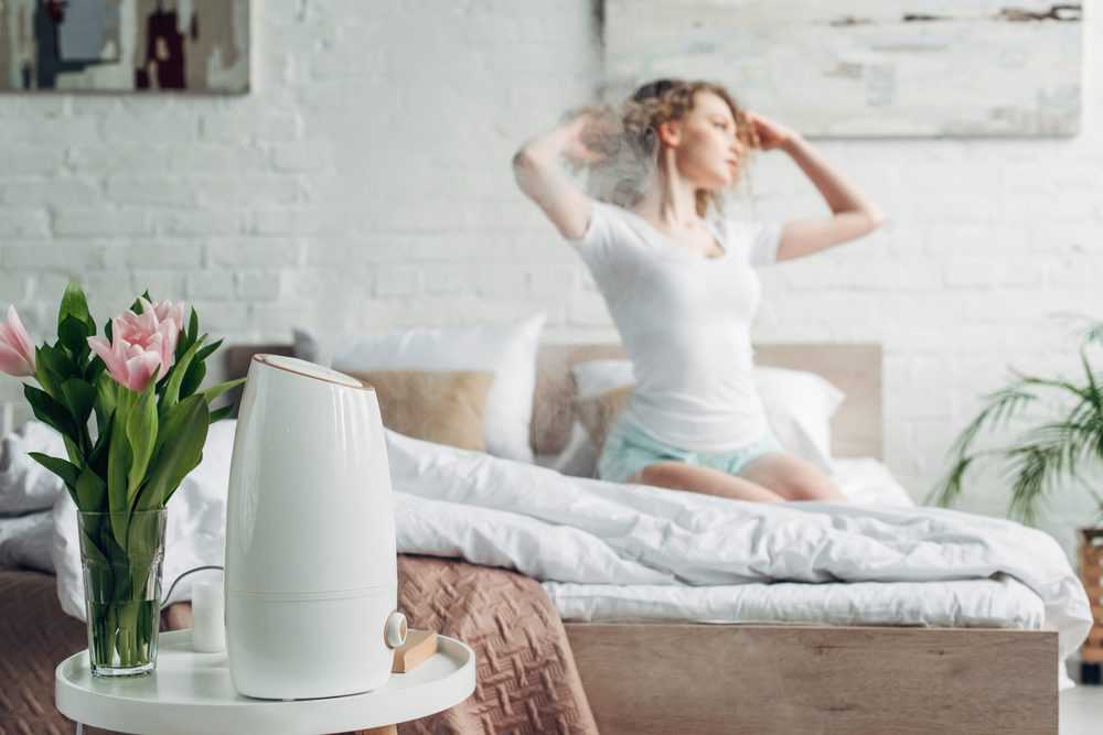 Woman waking up with a humidifier running in the bedroom