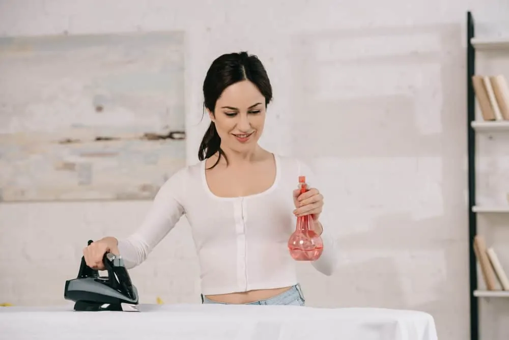 Woman using vinegar to iron