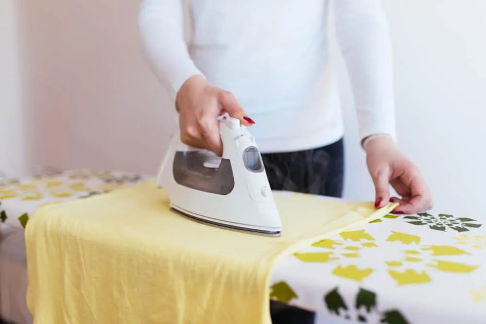 Woman using a nice ironing board cover while ironing