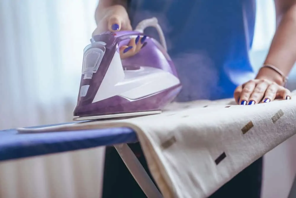 Woman ironing clothes with a steam iron