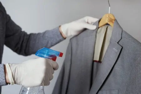 Man spraying a wrinkle remover on a business suit