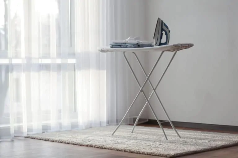 Folding a standing ironing board