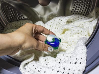 Man doing laundry with a laundry pod