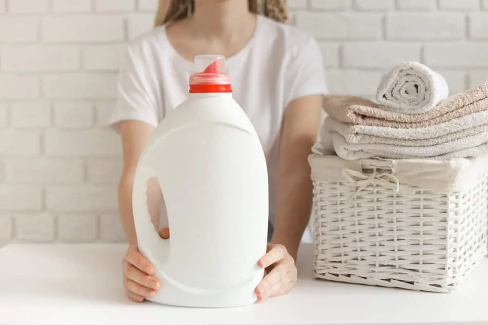 Femme tenant une bouteille d'adoucissant pour le linge