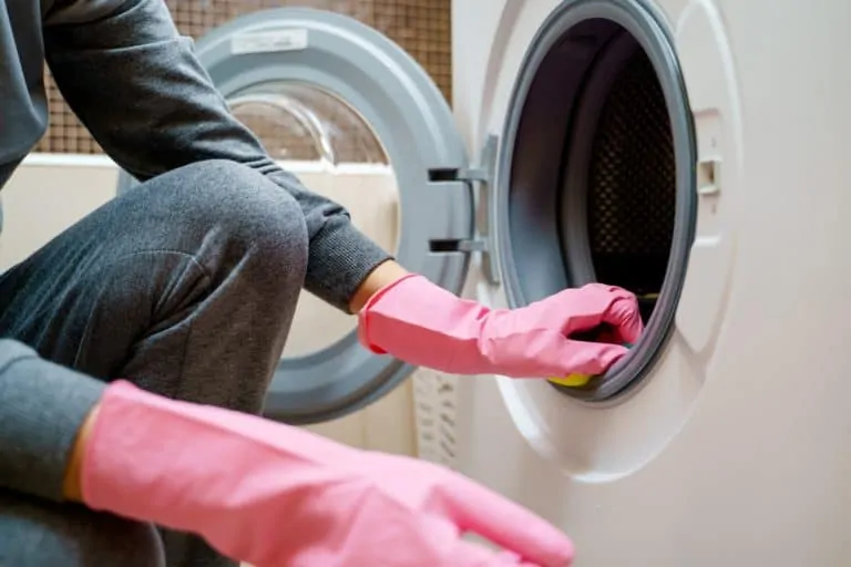 Woman cleaning a washing machine