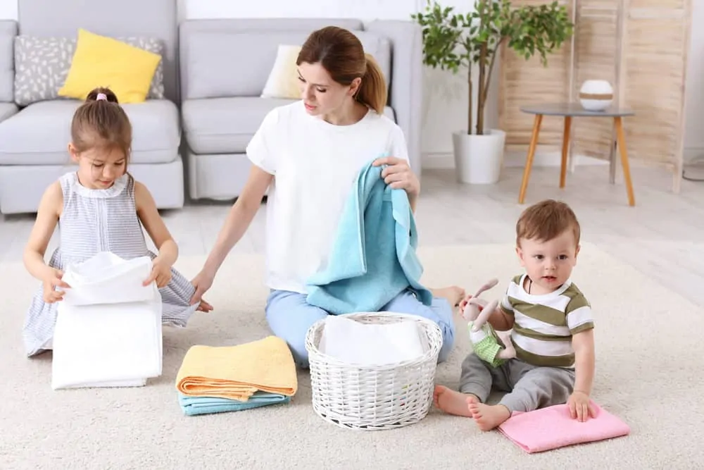 Woman folding laundry with her kids