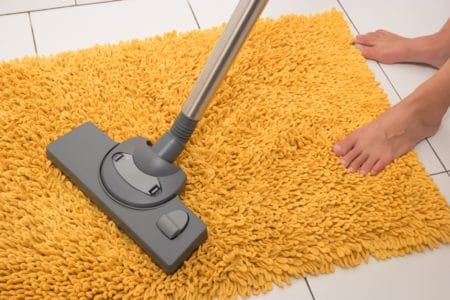 Vacuuming a bathroom rug