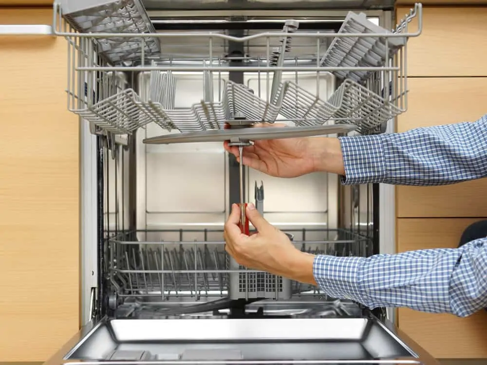 Man unclogging a dishwasher