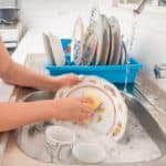 Woman washing the dishes in the kitchen sink