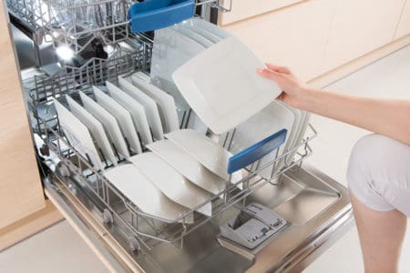 Woman taking out dry dishes from dishwasher