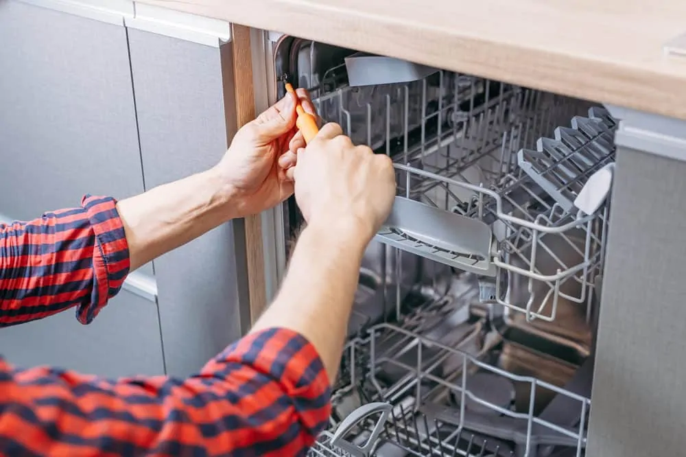 Man removing dishwasher from kitchen
