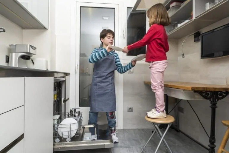 Siblings emptying the dishwasher