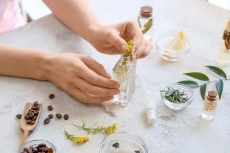 A hand of a person making homemade air freshener at table