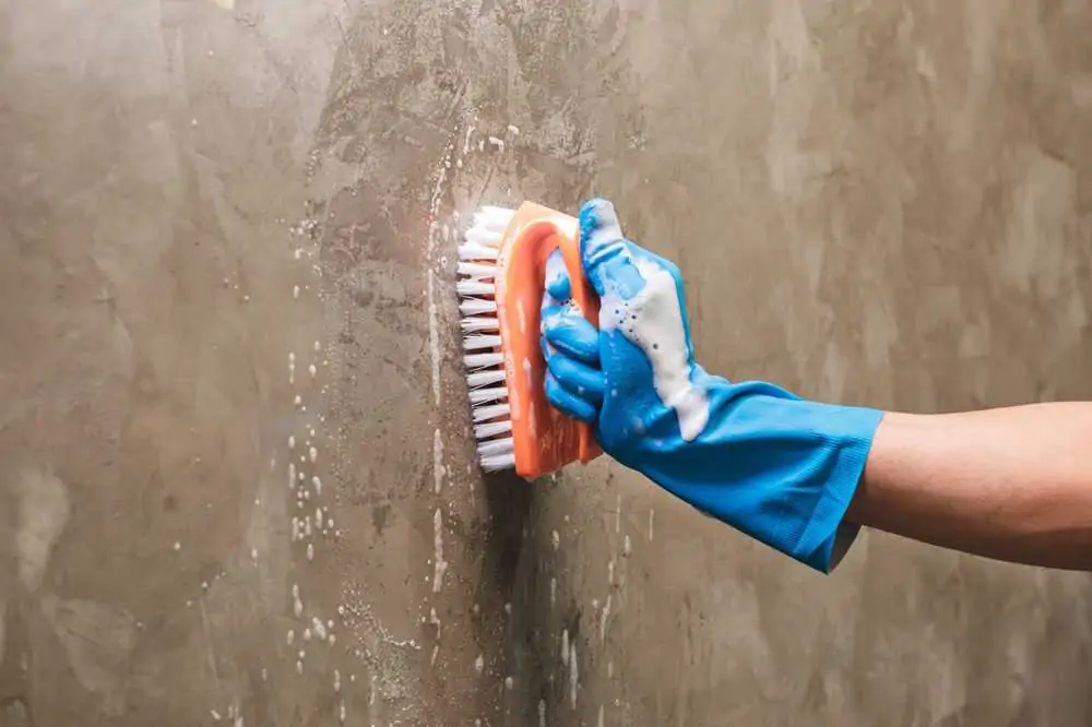 Cleaning the concrete wall with soap solution