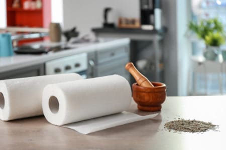 Rolls of paper towels, mortar and pestle on kitchen table