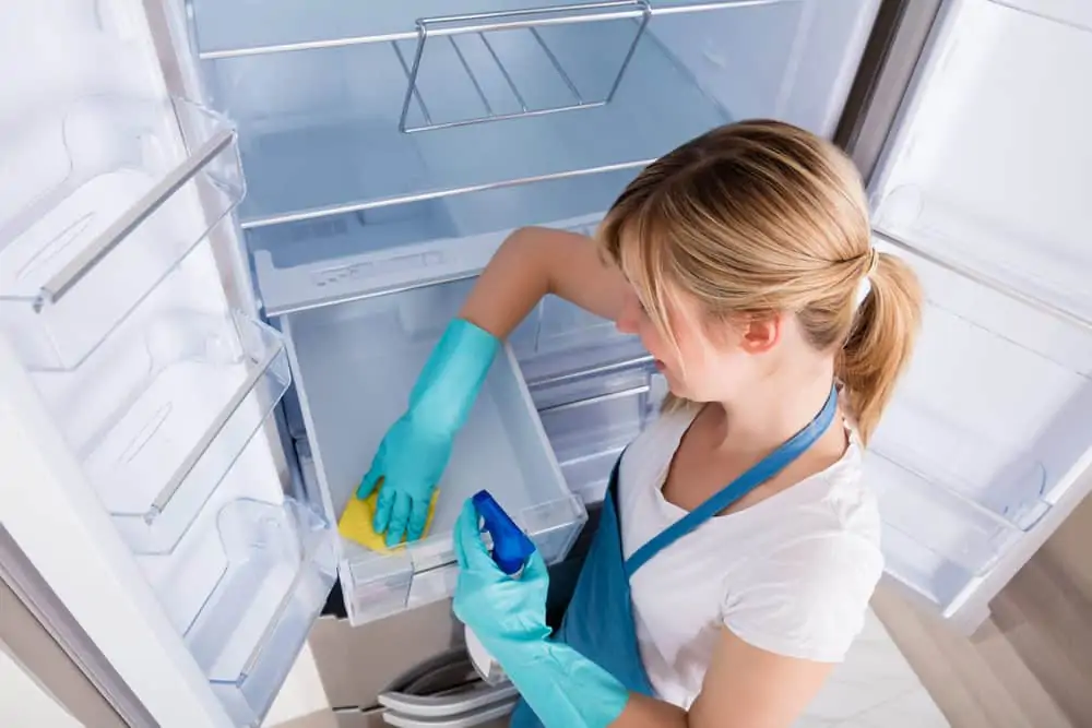 Woman cleaning the fridge