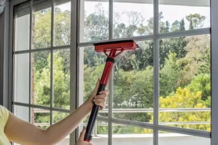 Woman cleaning window glass with steam mop