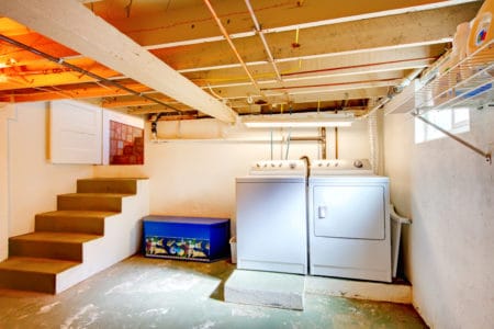 Basement laundry room with old appliances.
