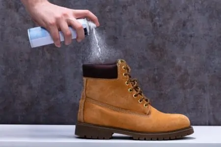 Spraying anti-odor spray to leather boots