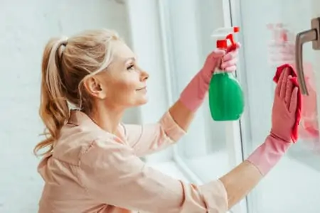 Woman cleaning window with a homemade cleaning solution