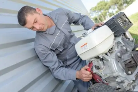 Man changing pressure washer pump oil