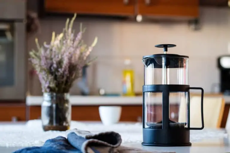 Clean french press glass, cloth, and yerba on top of kitchen table