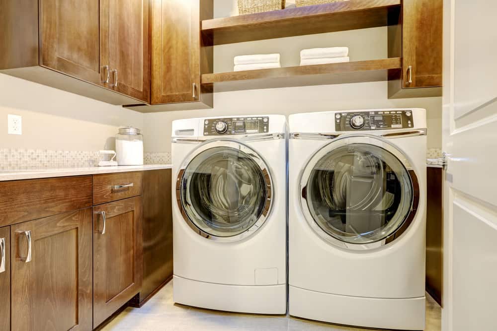 White and brown laundry room with modern front load washer