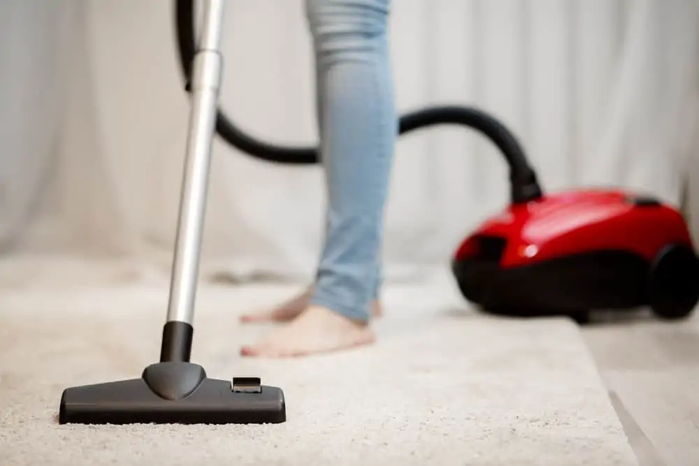 Woman vacuuming wool rug