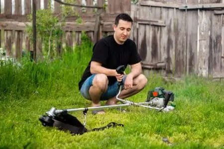 Man holding a gas trimmer in the garden