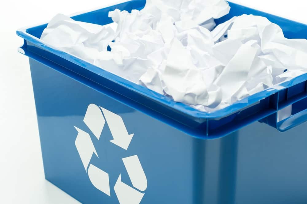 Blue recycle bin with paper waste
