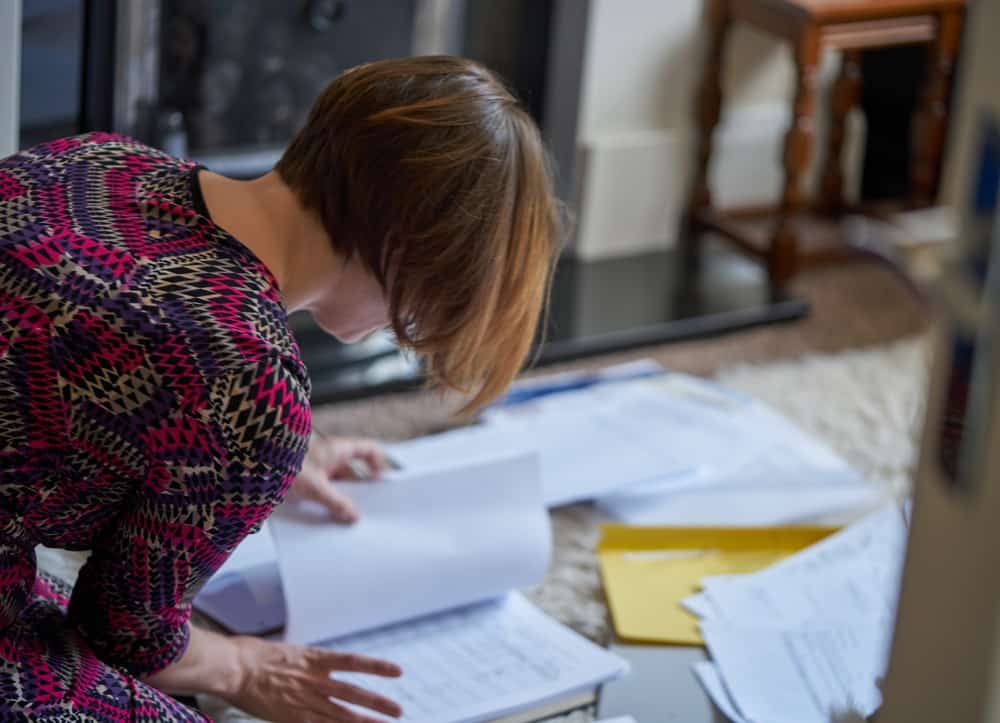 Woman searching through documents on the home office table