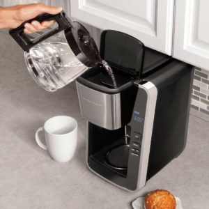 Hand pouring water into Hamilton Beach Coffee Maker
