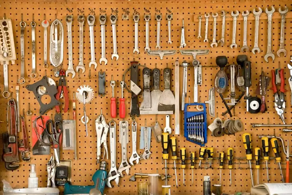 Different tools hanging on a peg board in a garage