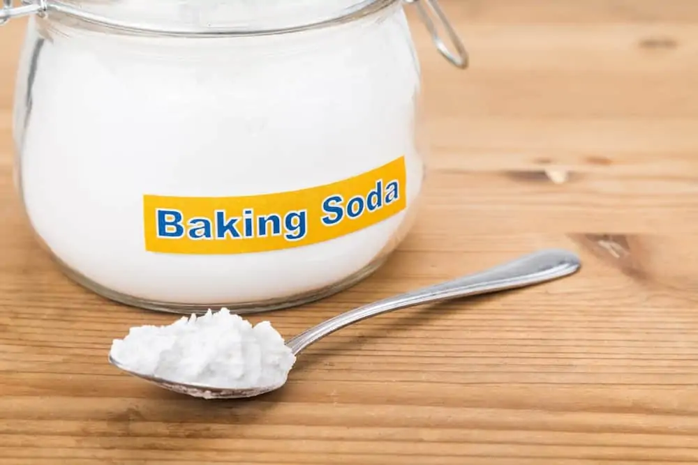 Glass jar and spoonful of baking soda on the table