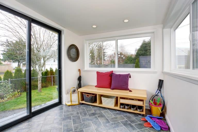 Small mudroom with sliding glass door, bench, and storage boxes