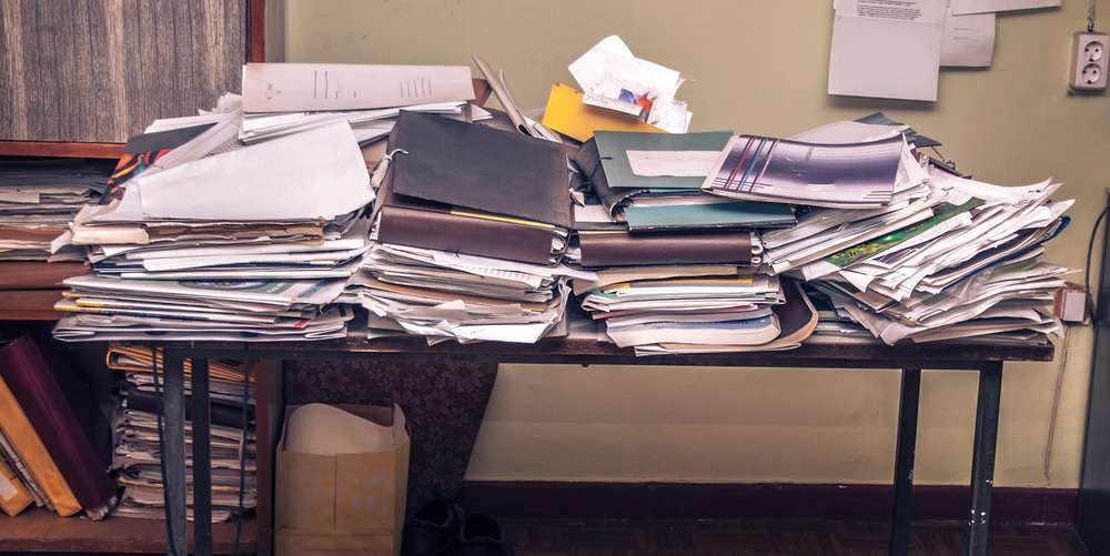 Messy workplace with stack of old papers